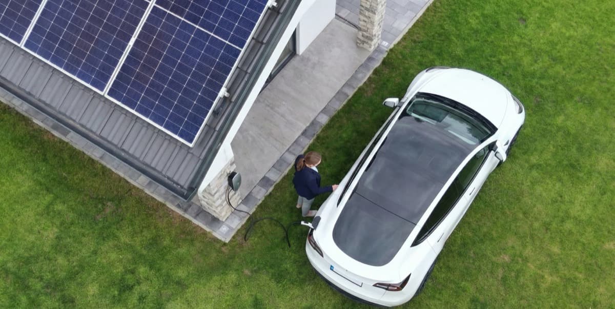 Aerial view of home with solar panels and electric vehicle charging